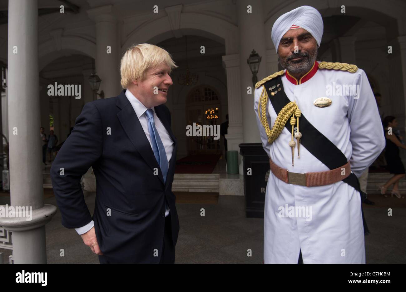 London Mayor Boris Johnson is met by Doorman, Narajan at Raffles Hotel in Singapore before he addressed the Singapore British Chamber of Commerce. Stock Photo