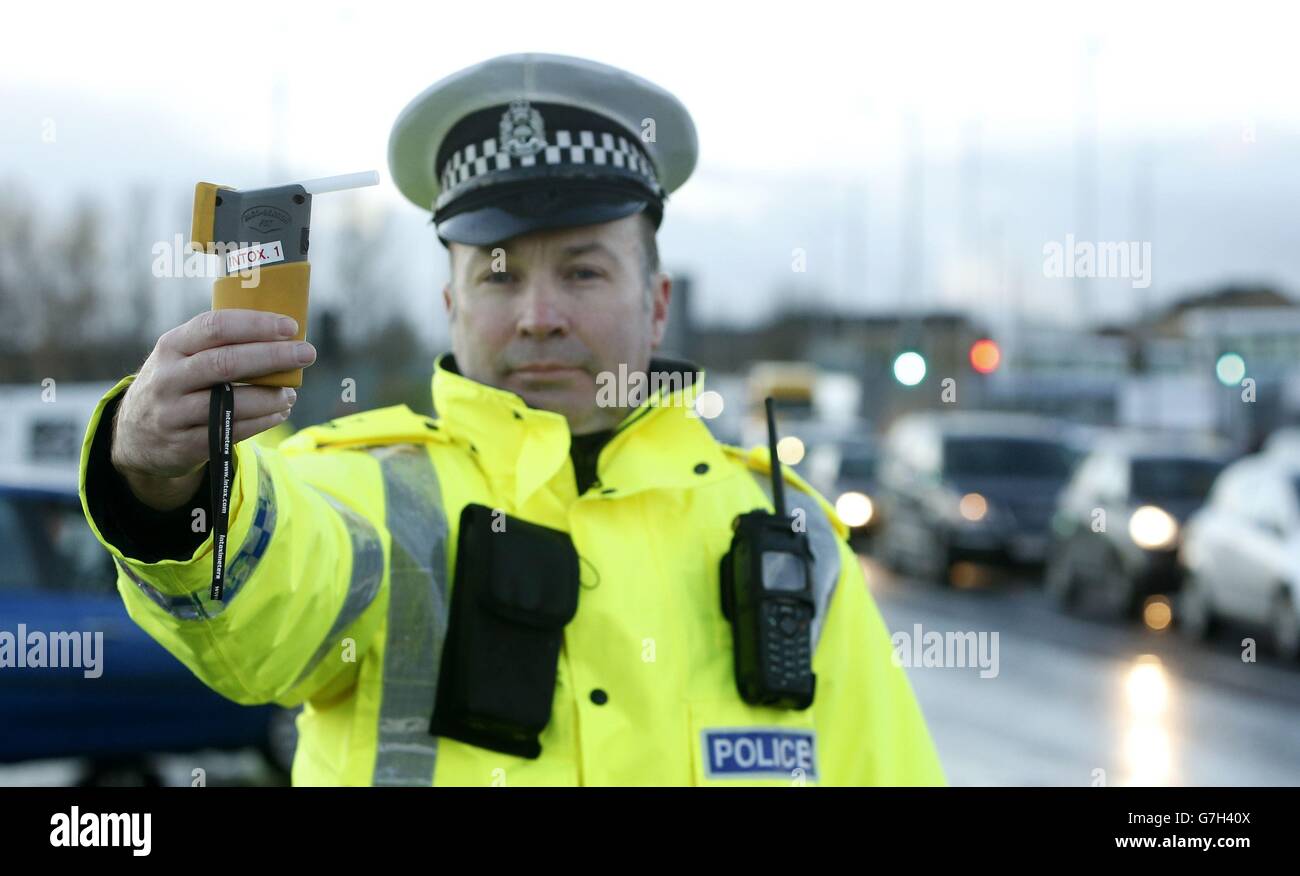 A police officer presents a breathalyser in Glasgow during a festive drink-drive campaign, as a stricter drink-drive limit has come into force today in Scotland, making it lower than the rest of the UK. Stock Photo