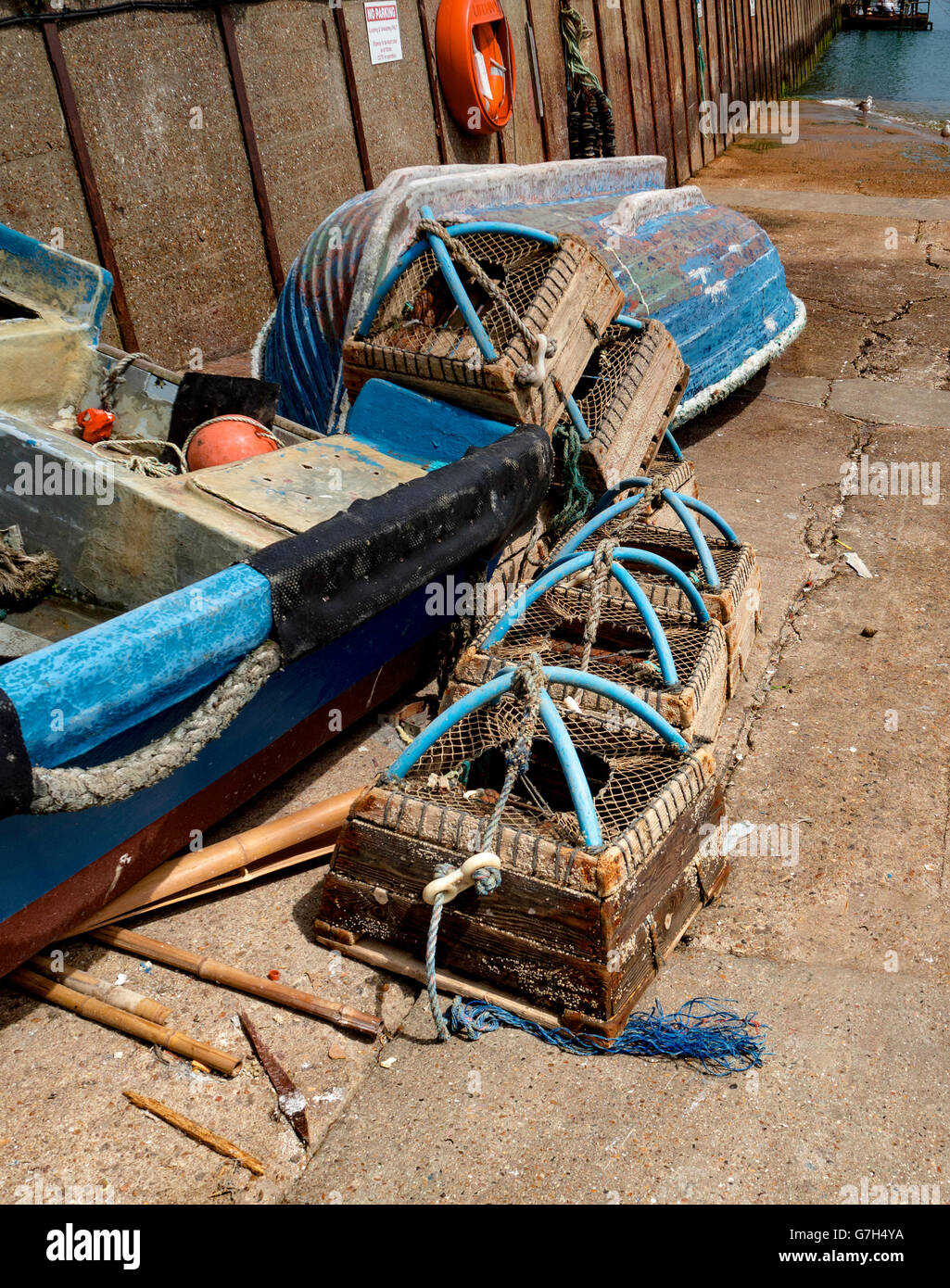 Lobster pots and an upturned boat on the quay side. Stock Photo