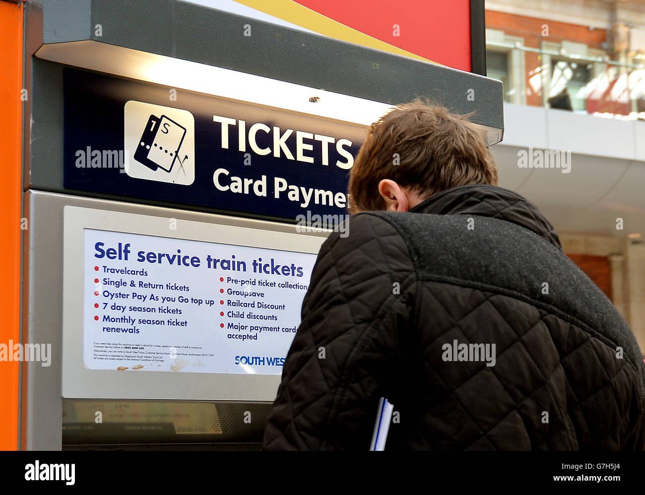 Train passengers buy their tickets at Waterloo Station in central