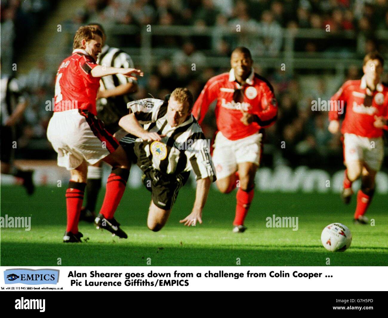 Alan Shearer, Newcastle United goes down from a challenge from Colin Cooper, Nottingham Forest Stock Photo