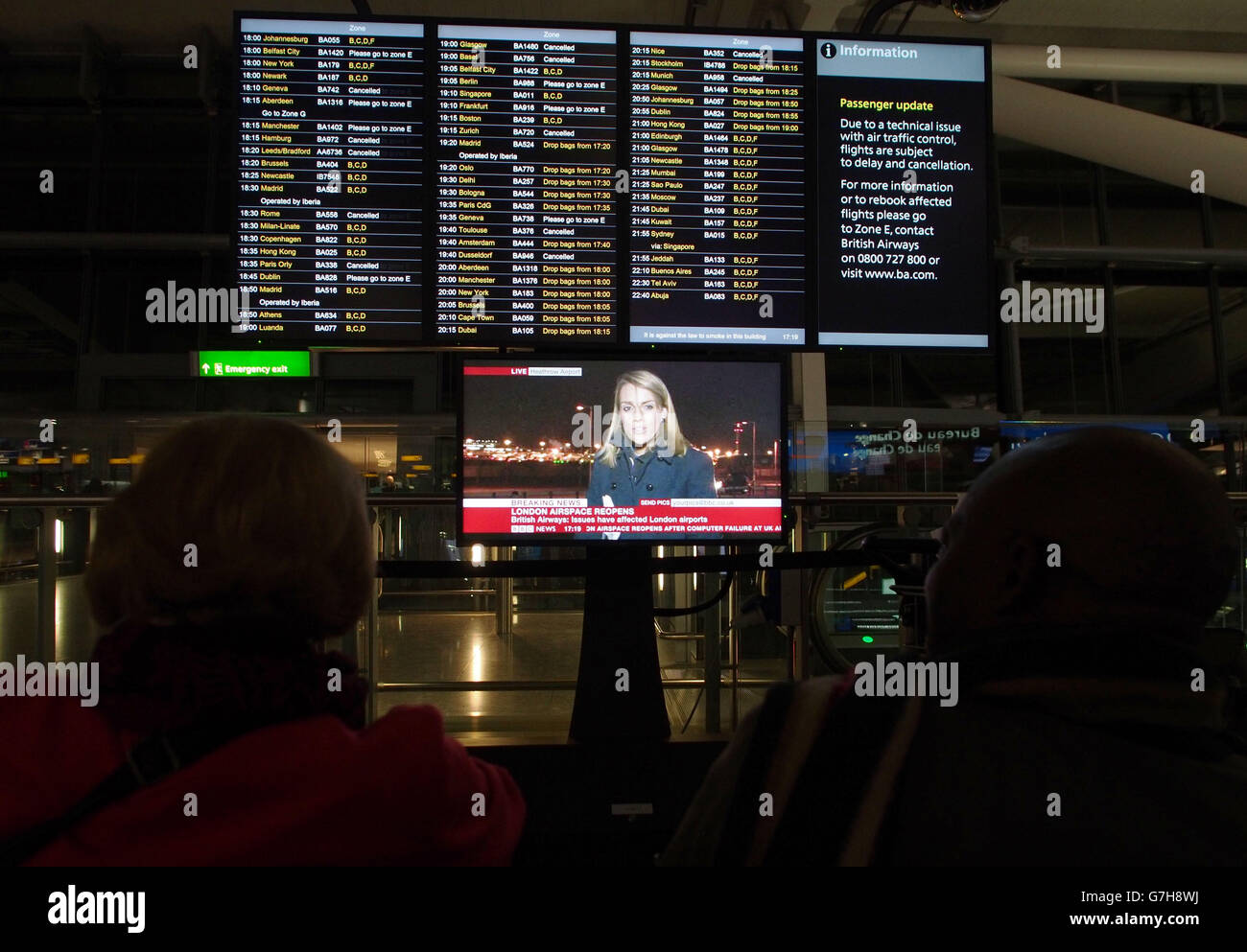 People watch an information board at Terminal 5 of Heathrow Airport as ...