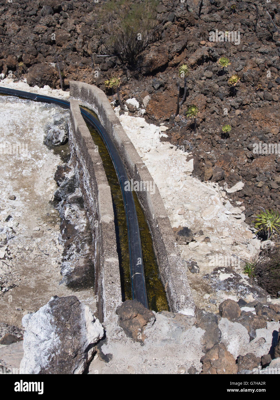 Tenerife Canary Islands Spain, open concrete water canal near Arguayo through lava fields carrying water to the fields Stock Photo