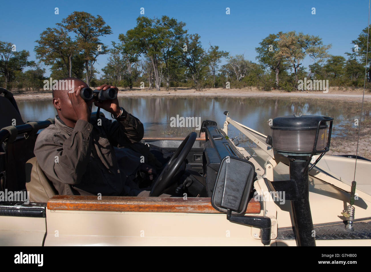 Man with binoculars, Savute Channel, Linyanti, Botswana, Africa Stock Photo