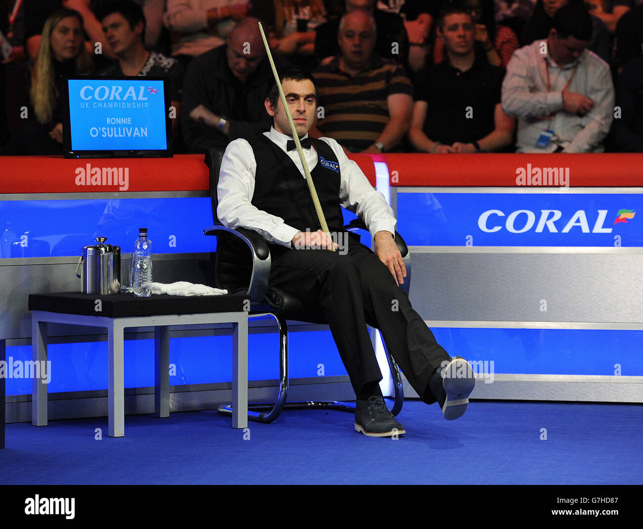 Ronnie O'Sullivan flexes his damaged ankle as he sits in his chair in his second round match against Peter Lines during the 2014 Coral UK Championship at the Barbican Centre, York. Stock Photo