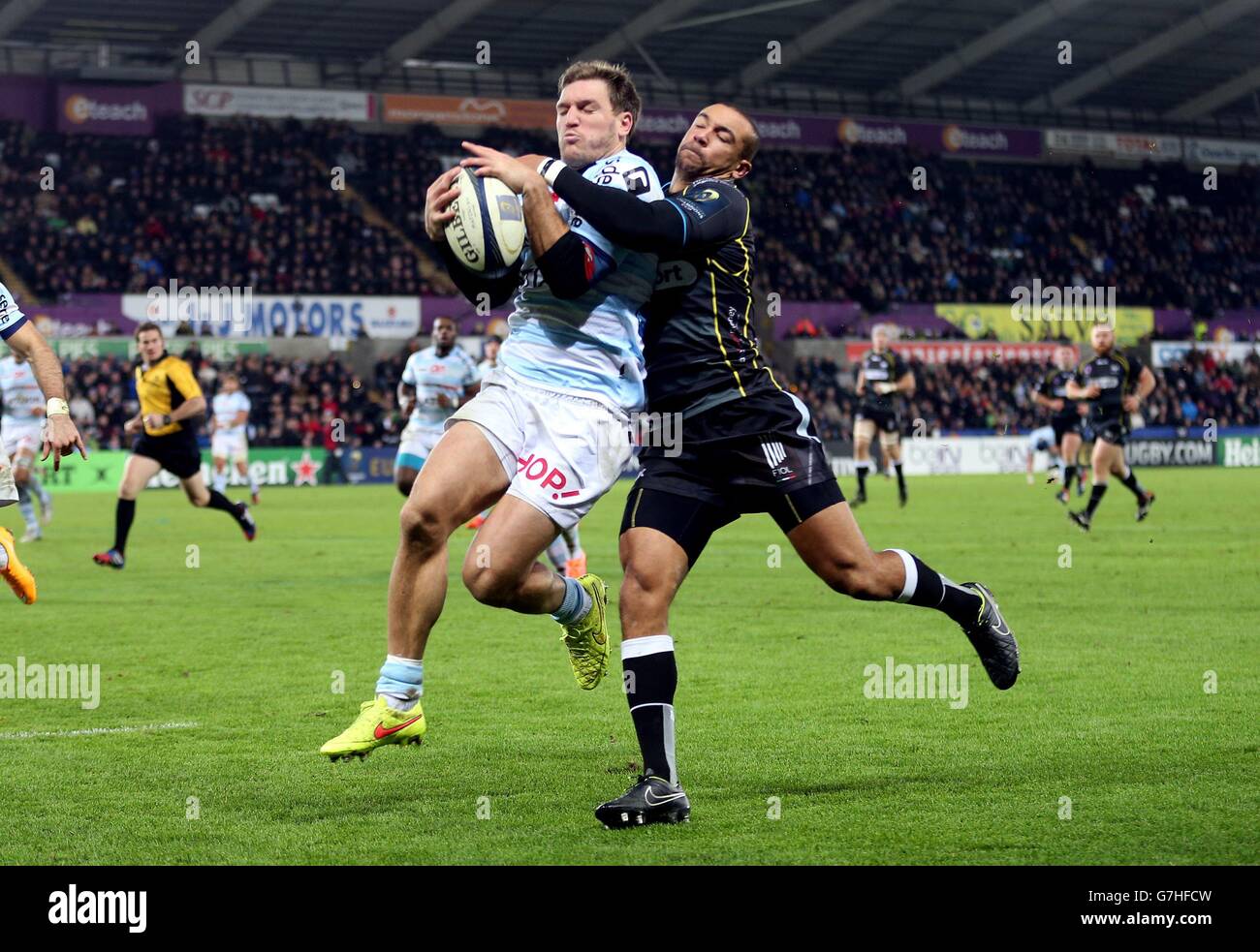 Racing Metro's Adrien Plante is tackled by Ospreys Eli Walker during the Pool Five match of the European Rugby Champions Cup at the Liberty Stadium, Swansea. Stock Photo