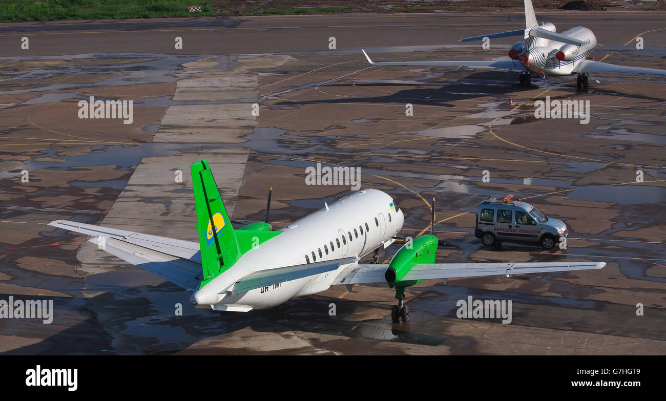 Kiev, Ukraine - May 17, 2012: South Airlines Saab 340B parked on the apron of the airport with another plane and a 'Follow Me' c Stock Photo