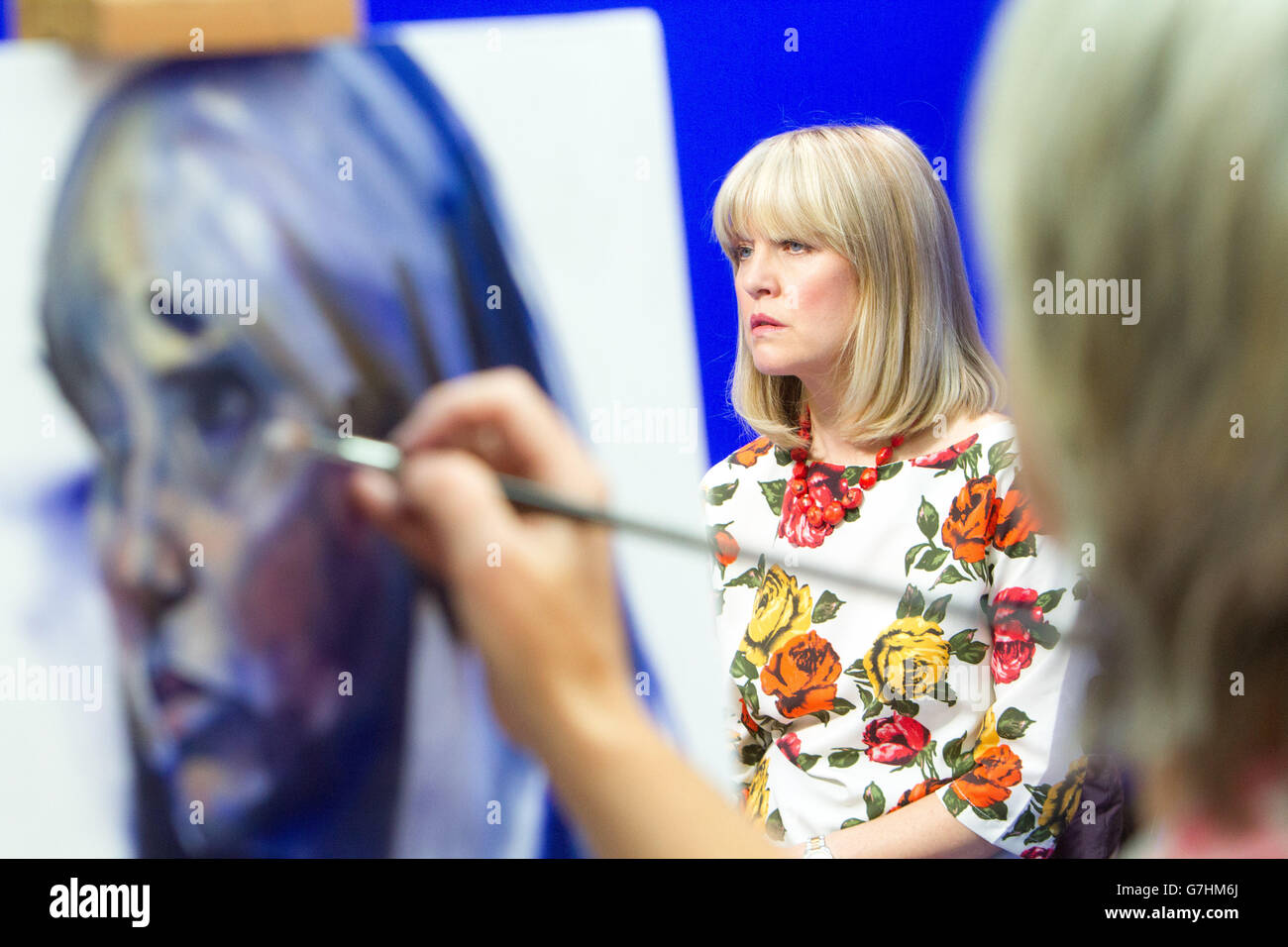 Artist painting portrait of Ashley Jensen at Easel Stock Photo