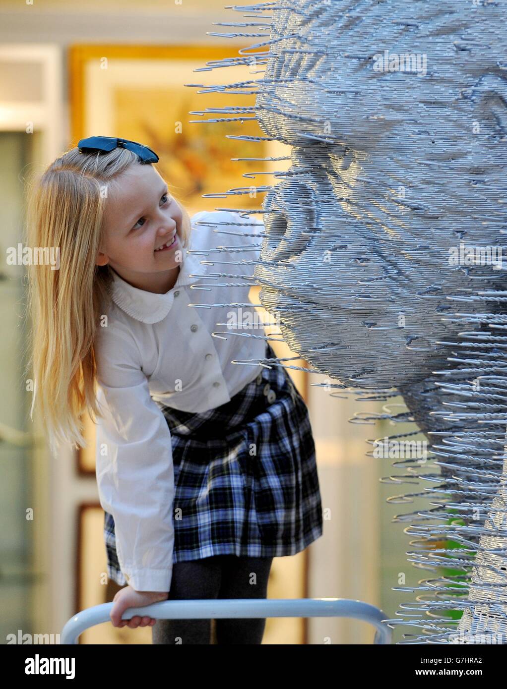 Pia Kebell, seven, studies 'Silver Back' a larger than life-size two-meter tall gorilla made entirely of wire coat hangers with an estimate of £60,000 - £80,000, by artist David Mach during a photo call and preview of Christie's forthcoming Creatures Great and Small sale, a themed auction which celebrates the animal as inspiration and takes place on December 17th at Christie's, in Old Brompton Road, London. Stock Photo