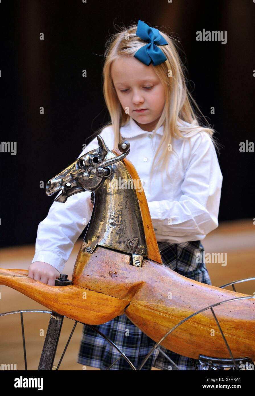 Pia Kebell, seven, plays with a 19th Century French steel and wood horse tricycle, during a photo call and preview of Christie's forthcoming Creatures Great and Small sale, a themed auction which celebrates the animal as inspiration and takes place on December 17th at Christie's, in Old Brompton Road, London. Stock Photo