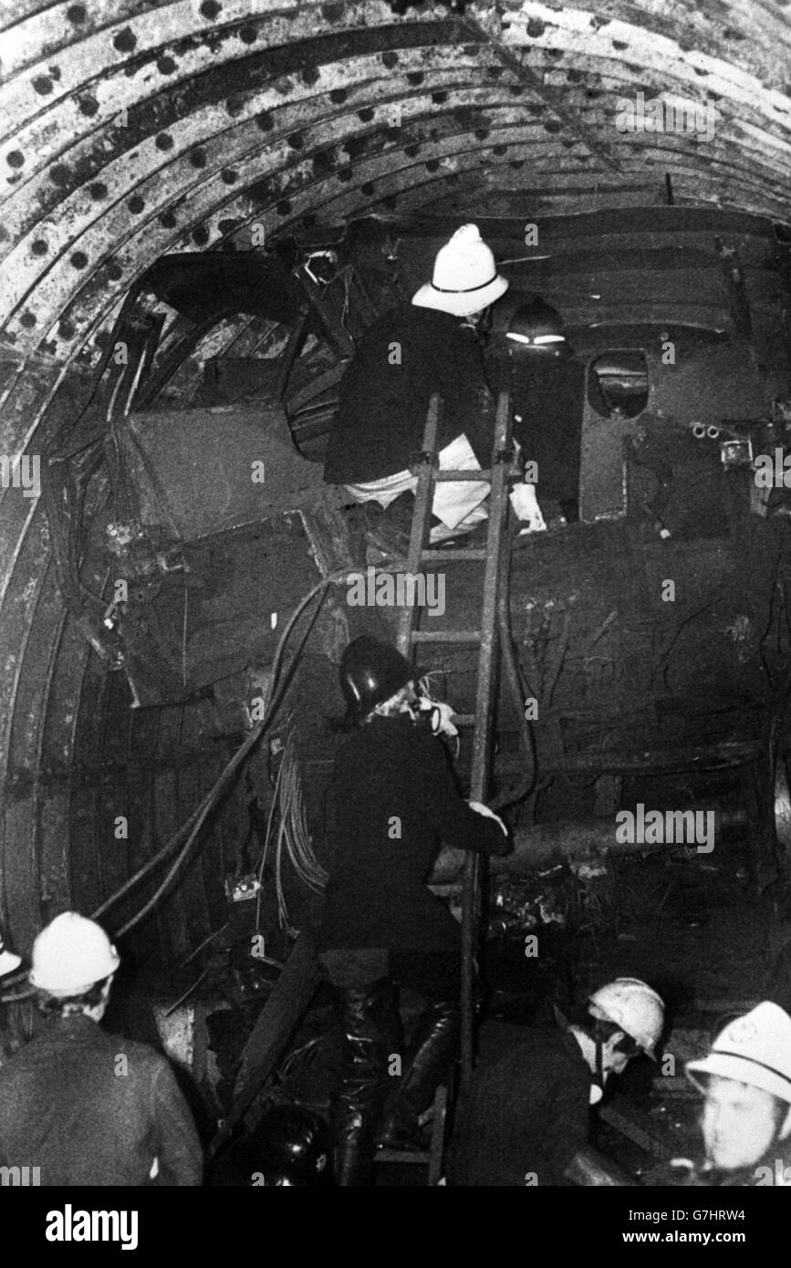 Firemen entering the wrecked front carriage of the train at Moorgate as they help rescue teams to free trapped bodies from the tangled wreck. Stock Photo
