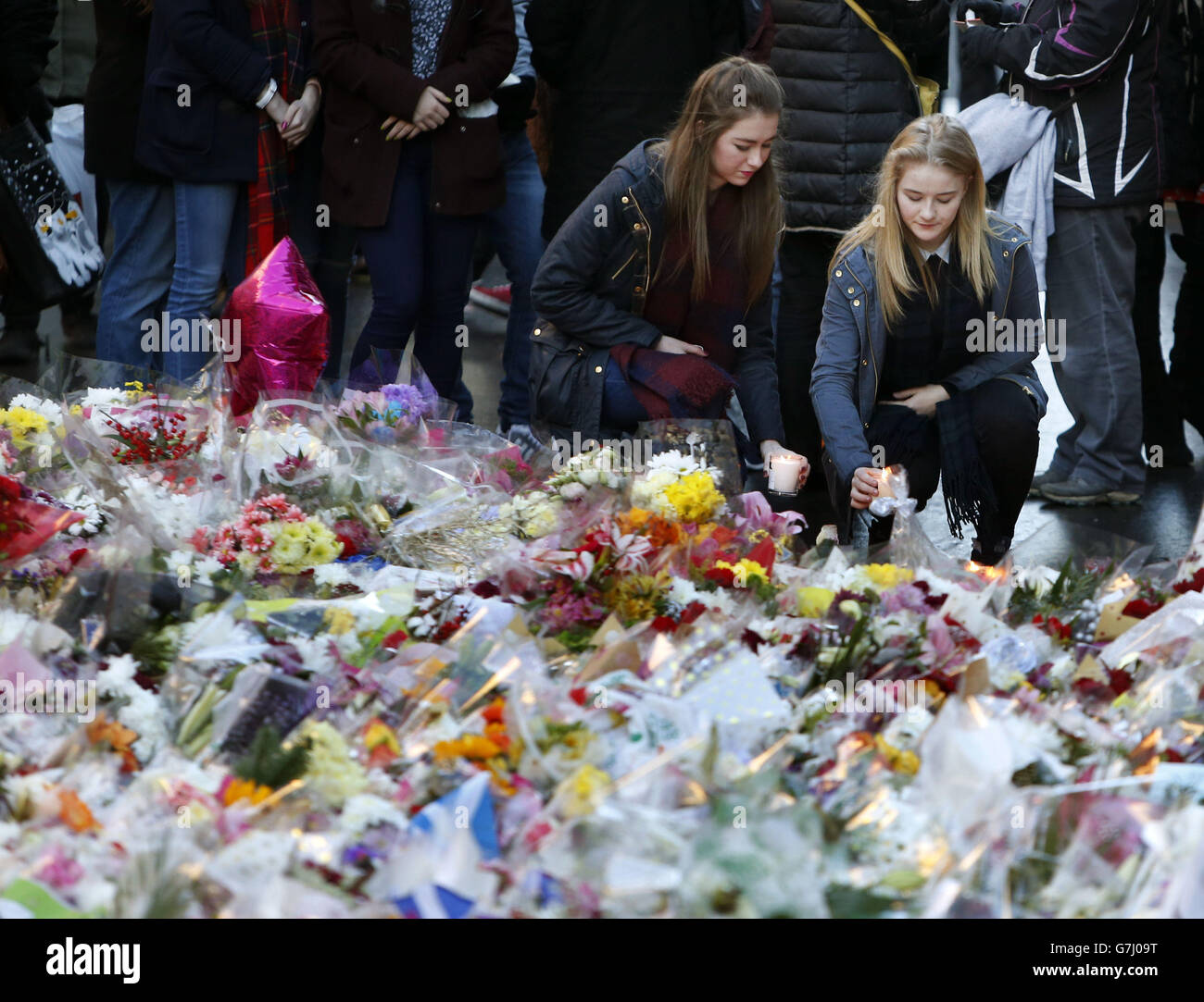 People lay candles as hundreds of people attend a vigil near the Gallery of Modern Art in Glasgow, after a lorry lost control killing six people. Stock Photo