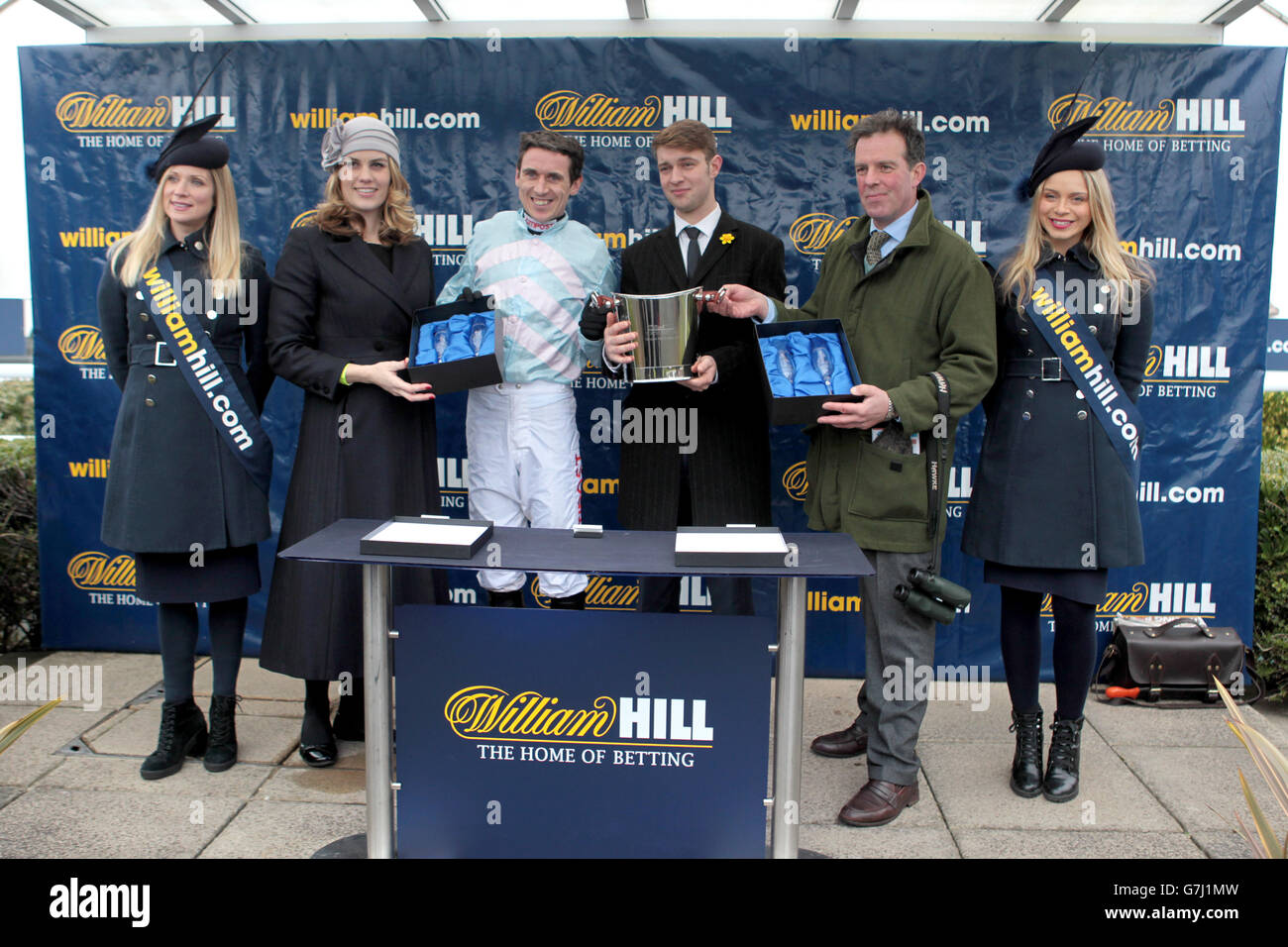 The presentation to the winning connections of Stellar Notion including trainer Tom George (second right) and jockey Paddy Brennan (centre left) after victory in the William Hill - Download The App Novices' Limited Handicap Chase Stock Photo