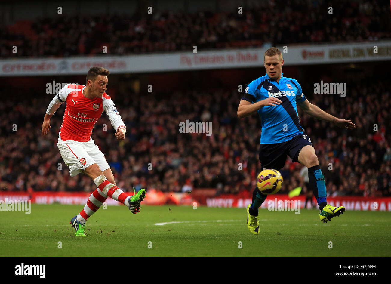 Arsenal's Mesut Ozil shoots during the Barclays Premier League match at the Emirates Stadium, London. Stock Photo