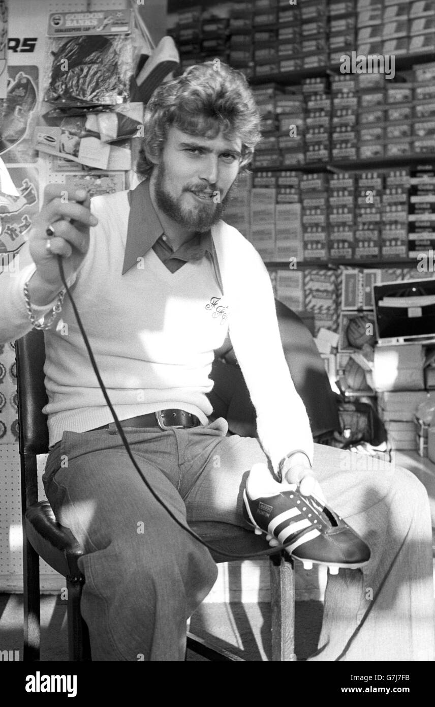 Fulham striker Viv Busby laces up a pair of football boots in his sport shop in Oxford Street, ahead of Fulham's Cup match against Everton. Stock Photo
