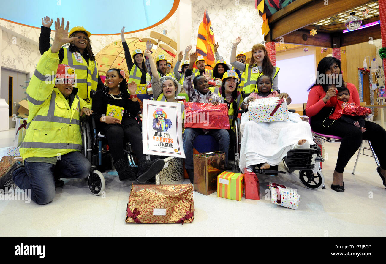 Young patients Rhyanne Gasper, aged 14, from Newham in London (2nd left), Naeem Agbongbon, eight, from Ockenden in Essex (4th left), Eron Ufuah, nine, from Canning Town in London (2nd right) and Harshika Partheepan, four months, from Newbury Park in London (right) receiving gifts from volunteers from the charity The Catlin Kindness Offensive at The Royal London Hospital in London. PRESS ASSOCIATION. Picture date: Thursday December 18, 2014. The charity have hand wrapped over twenty tonnes of gifts and distributed them to kids across London including children's hospitals Guy's, Barts and Stock Photo
