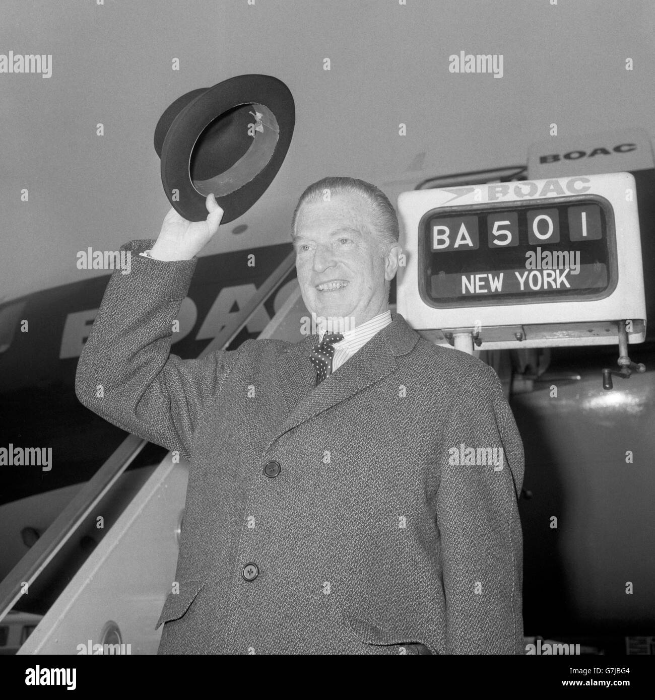 John Freeman, who after serving as British High Commissioner in India is to become Ambassador in Washington, United States, waves to the reporters as he boards the plane to Washington to take up his posts. John Freeman is a former Labour member of Parliament and also had a distinguished career as a journalist and broadcaster. He is former editor of the 'New Statesman' and as a television personality is remembered for his series of interviews under the title 'Face to Face'. Stock Photo