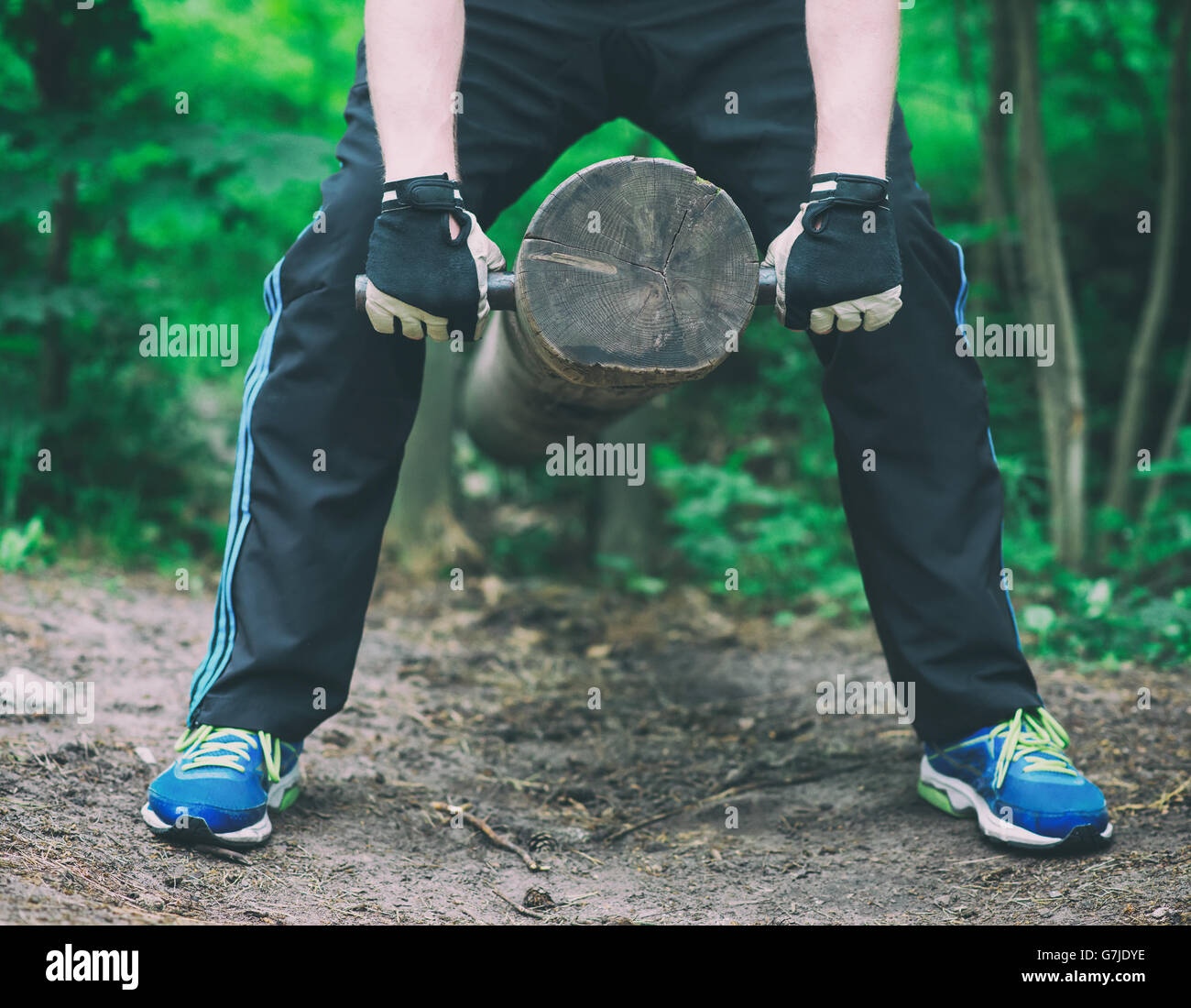 Man lifting log in the forest. Stock Photo
