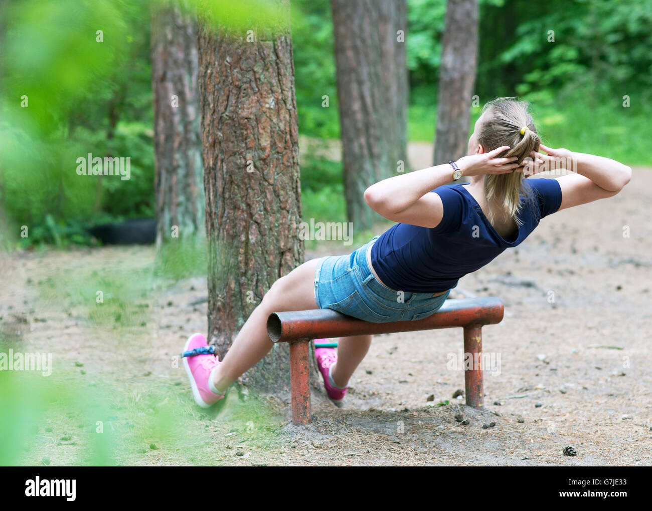 Woman doing abs workout in the forest. Stock Photo