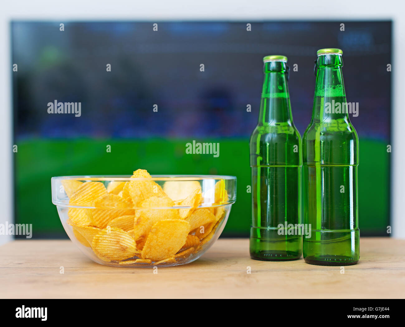 Beer and chips in front of TV with football match. Stock Photo