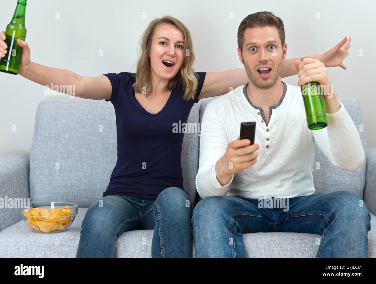 Excited couple watching sports match on tv. Stock Photo