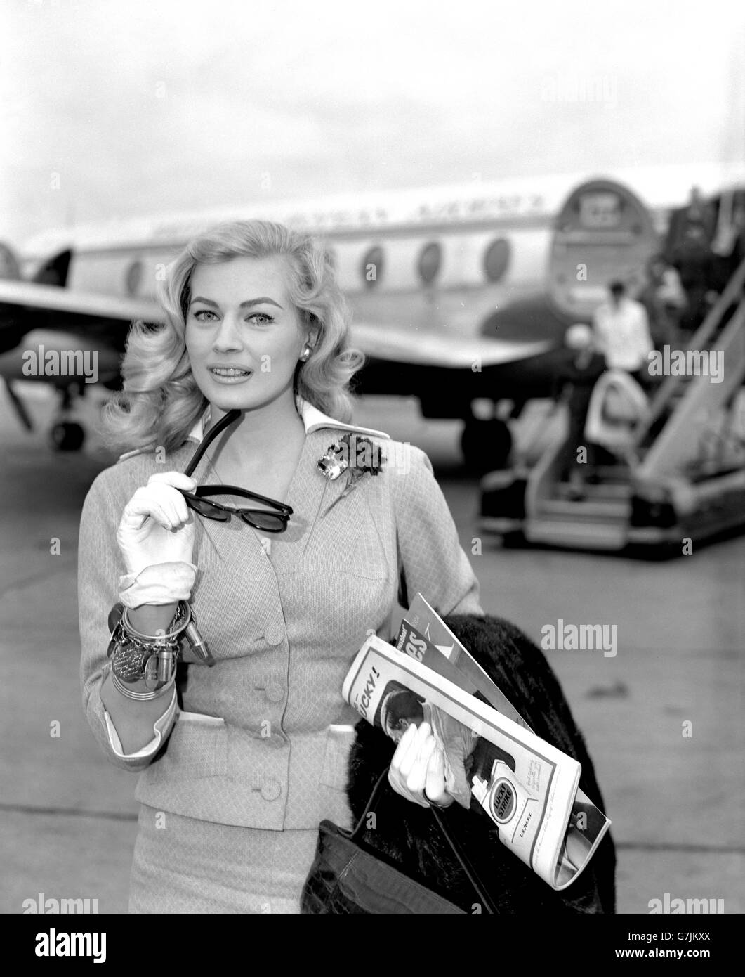 Actress Anita Ekberg smiles a greeting at London Airport. She has just flown in by BEA liner from Madrid to make a film, 'The Man Inside', for Warwick Films. Stock Photo