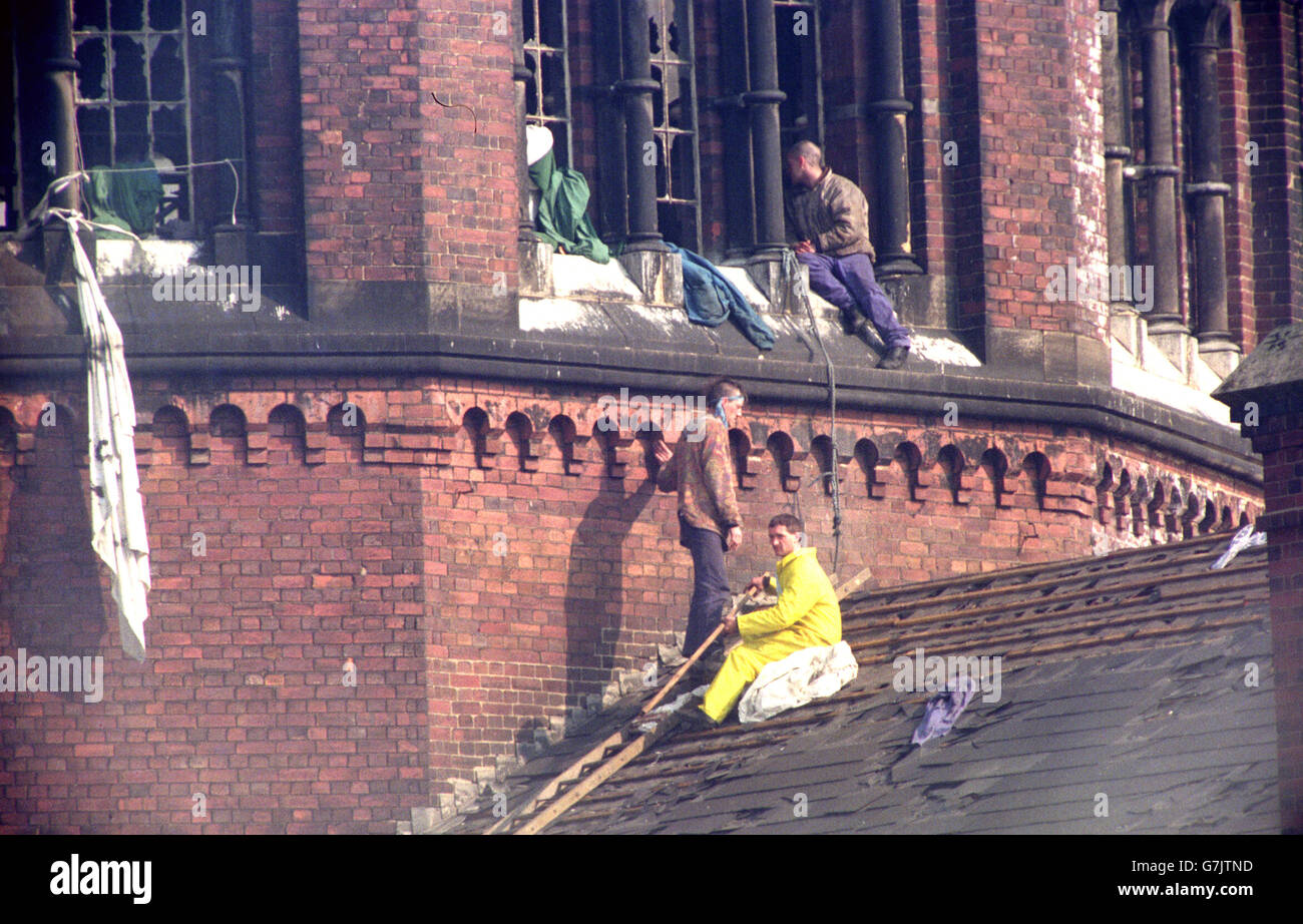 Two prisoners still showing defiance to pursuing prison officers after they were driven on to the roof of Strangeways prison. Stock Photo