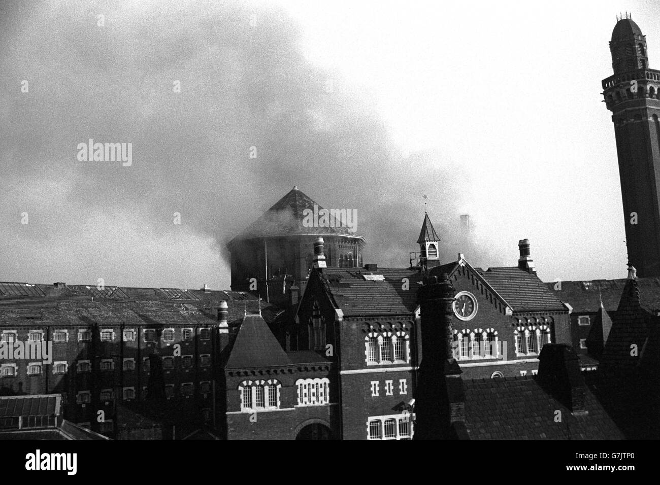 Smoke billows from the roof of Strangeways prison in Manchester after inmates set fire to debris piled inside. Stock Photo