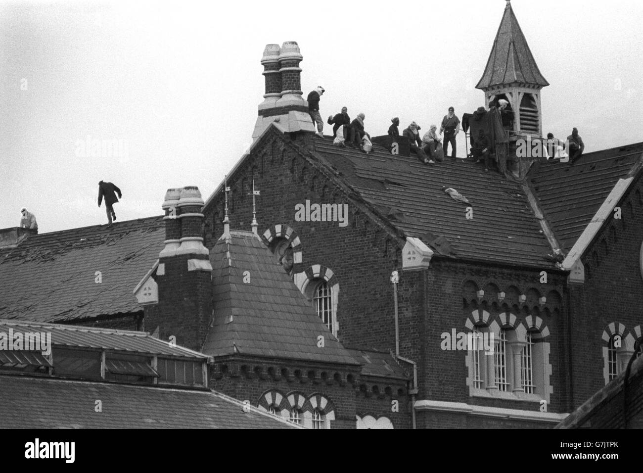 Prisoners take up their rooftop positions during rioting at Strangeways prison in Manchester. Stock Photo