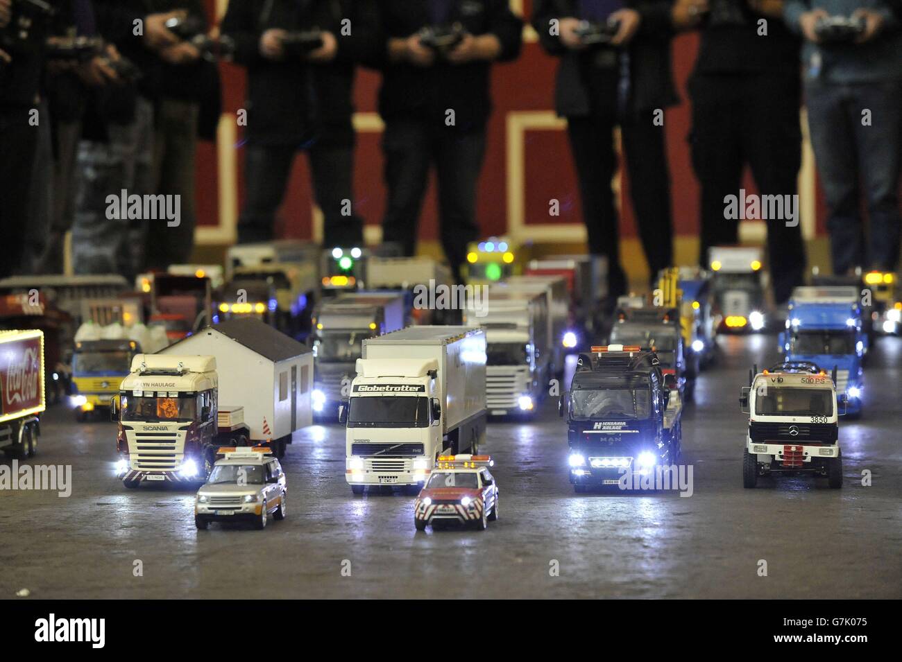 Operators stand behind their remote control trucks during the preview ...