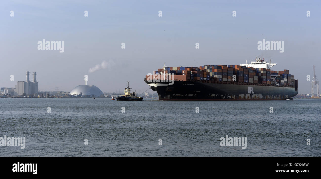 APL (American President Line) container ship Chongqing is towed by a tug boat makes it's way out of Southampton Port Stock Photo