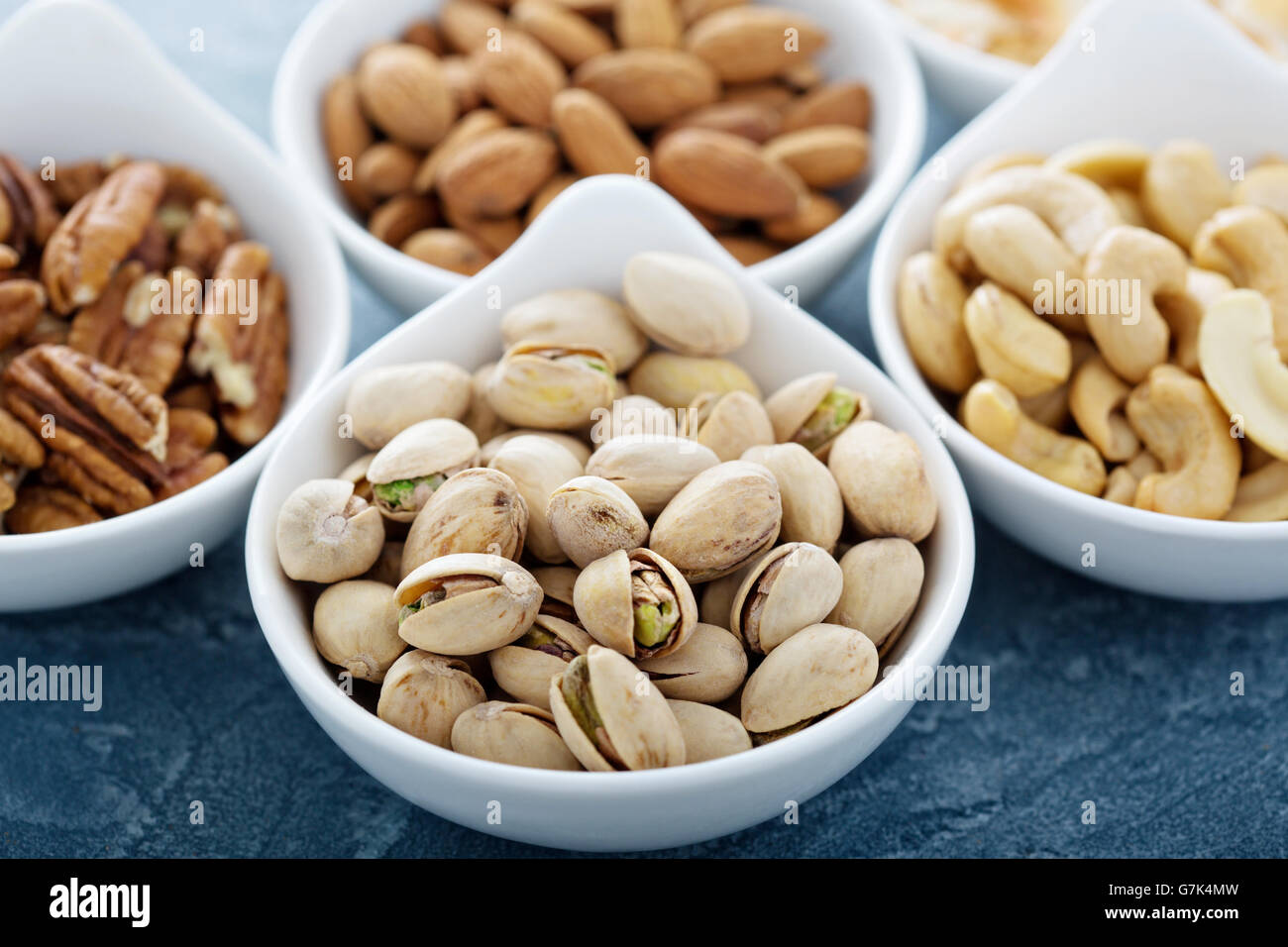Variety of nuts in small white bowls healthy snacks Stock Photo