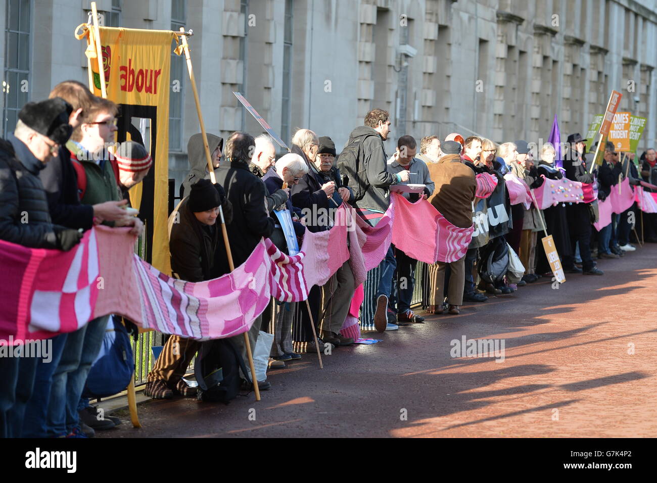 Protesters hold a scarf during a CND march against Trident nuclear missiles in London. PRESS ASSOCIATION Photo. Picture date: Saturday January 24, 2015. The pink-coloured scarf, knitted by people across the world, will encircle the Ministry of Defence building in central London as part of the demonstration. See PA story POLITICS CND. Photo credit should read: John Stillwell/PA Wire Stock Photo