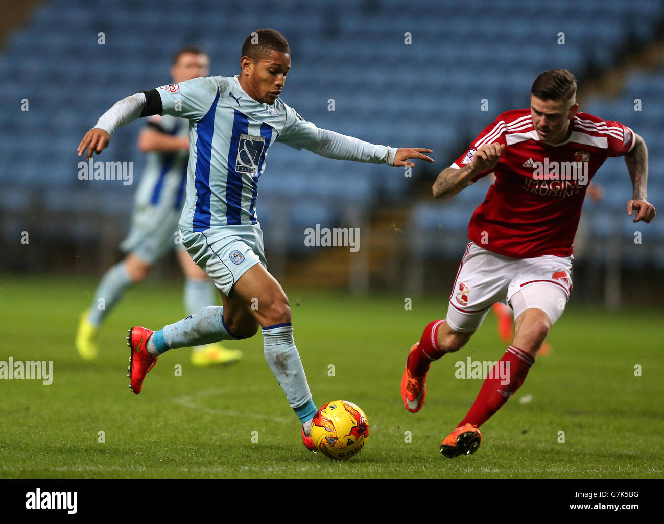 Coventry City's Simeon Jackson (left) and Swindon Town's Ben Gladwin battle for the ball Stock Photo