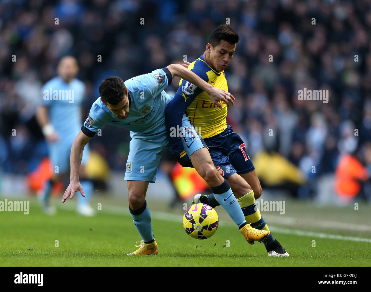 Arsenal's Alexis Sanchez (rightt) and Manchester City's Jesus Navas battle for the ball during the Barclays Premier League match at the Etihad Stadium, Manchester. Stock Photo