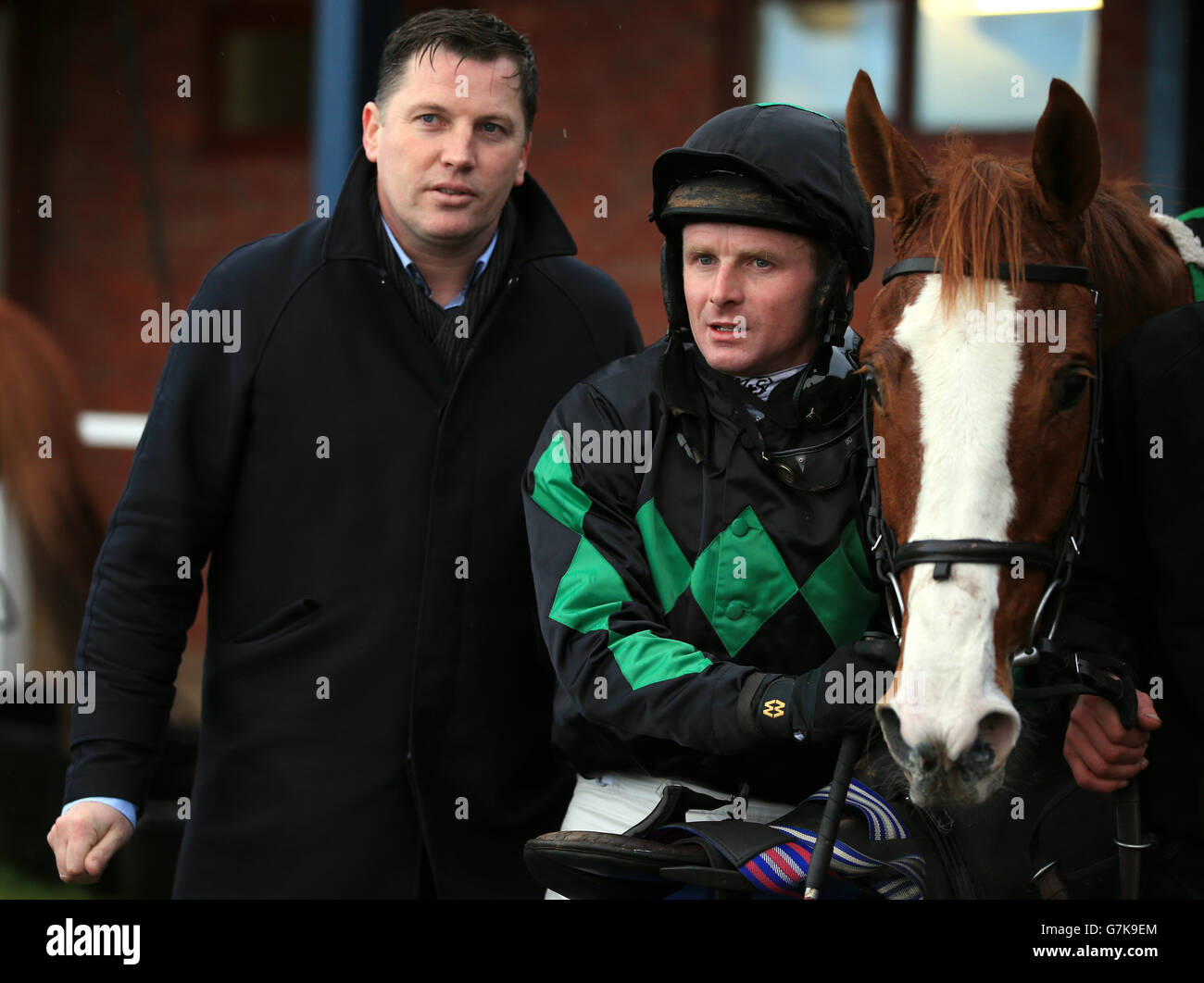 Horse racing agent Gearoid Costelloe (left) partner of trainer Rebecca Curtis with jockey Paul Moloney after win on Ballyhollow at Ludlow Racecourse, Shropshire. Stock Photo