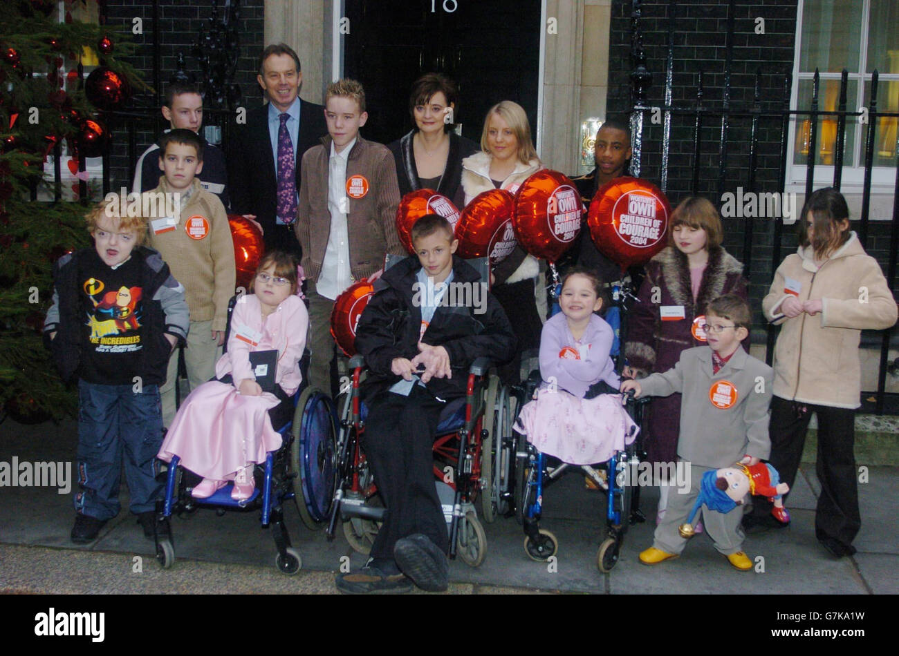 Prime Minister Tony Blair and his wife stand with children who have