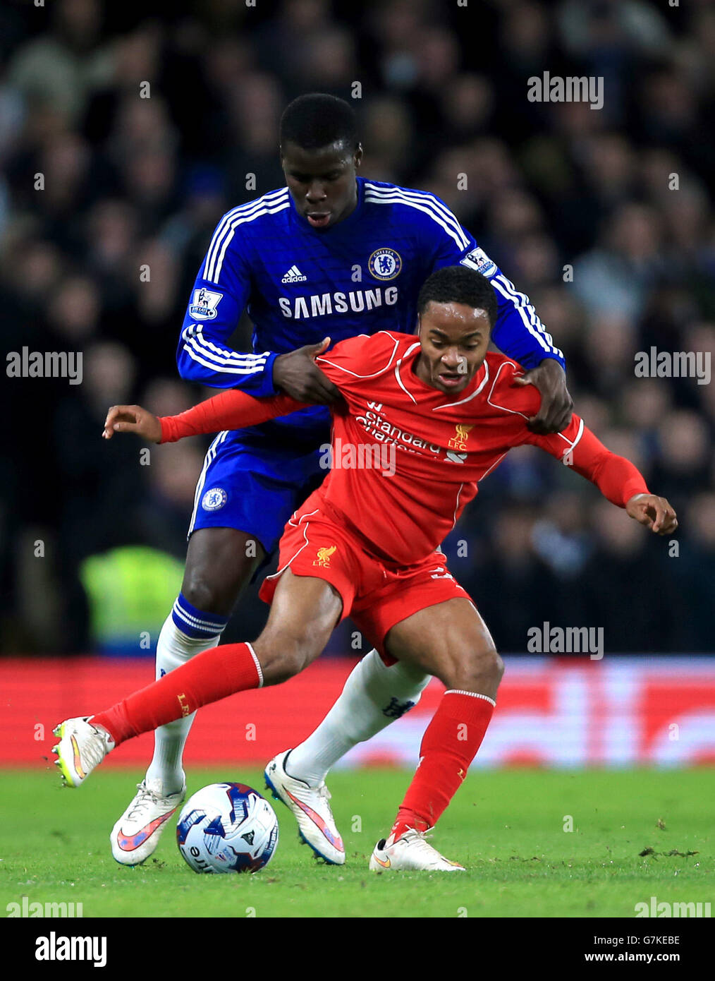 Chelsea's Kurt Zouma (left) and Liverpool's Raheem Sterling battle for the ball during the Capital One Cup Semi Final, Second Leg match at Stamford Bridge, London. PRESS ASSOCIATION Photo. Picture date: Tuesday January 27, 2015. See PA story: SOCCER Chelsea. Photo credit should read: Nick Potts/PA Wire. RESTRICTIONS: Maximum 45 images during a match. No video emulation or promotion as 'live'. No use in games, competitions, merchandise, betting or single club/player services. No use with unofficial audio, video, data, fixtures or club/league Stock Photo