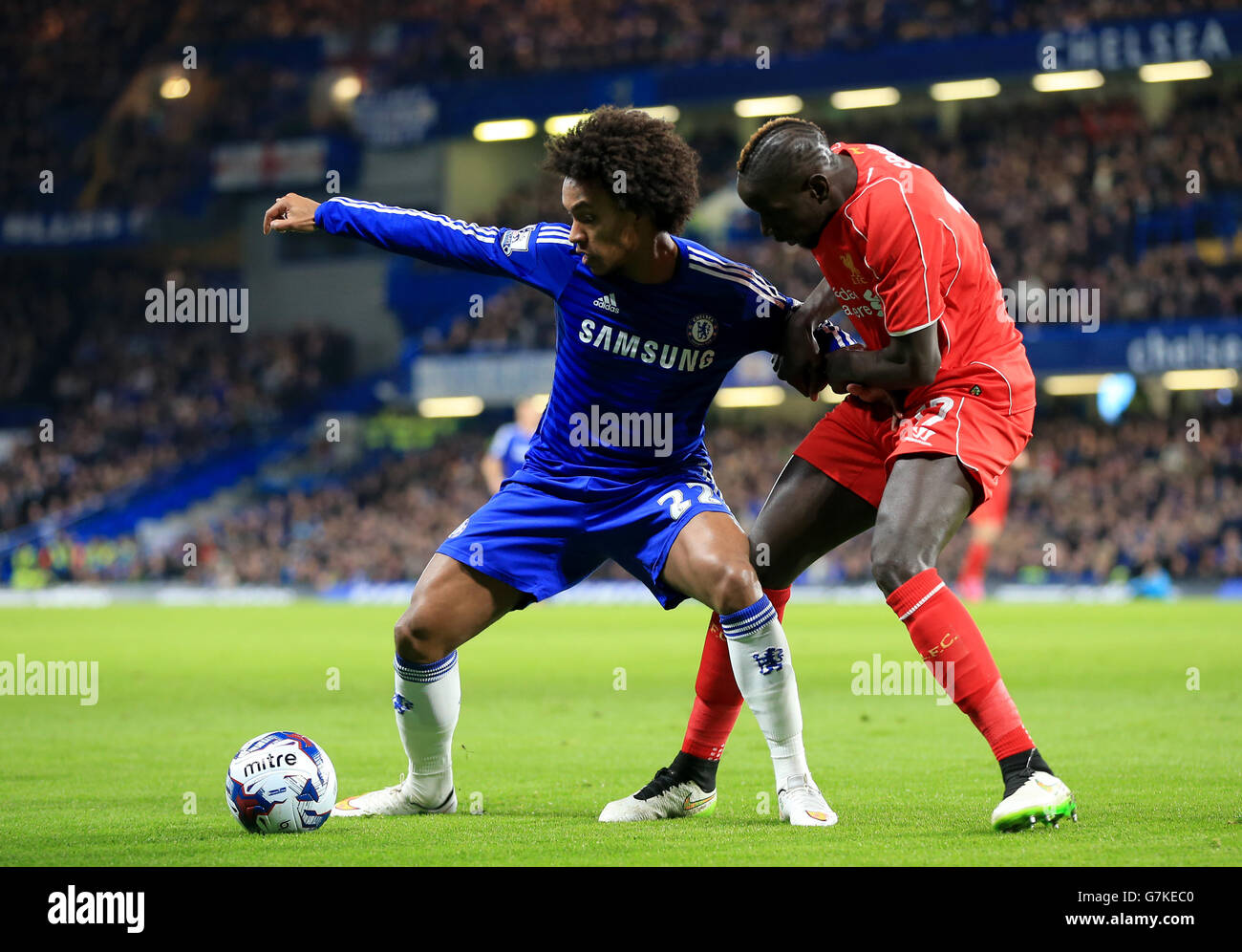 Chelsea's Willian (left) and Liverpool's Mamadou Sakho battle for the ball during the Capital One Cup Semi Final, Second Leg match at Stamford Bridge, London. PRESS ASSOCIATION Photo. Picture date: Tuesday January 27, 2015. See PA story: SOCCER Chelsea. Photo credit should read: Nick Potts/PA Wire. RESTRICTIONS: Maximum 45 images during a match. No video emulation or promotion as 'live'. No use in games, competitions, merchandise, betting or single club/player services. No use with unofficial audio, video, data, fixtures or club/league Stock Photo