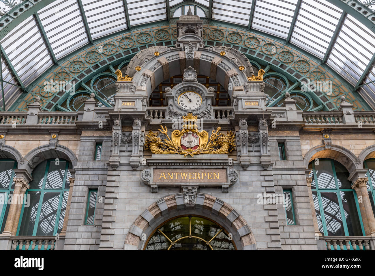 Main hall with clock and cityname 'Antwerpen' and dutch 'exit'sign of famous art deco station of Antwerp, Belgium Stock Photo