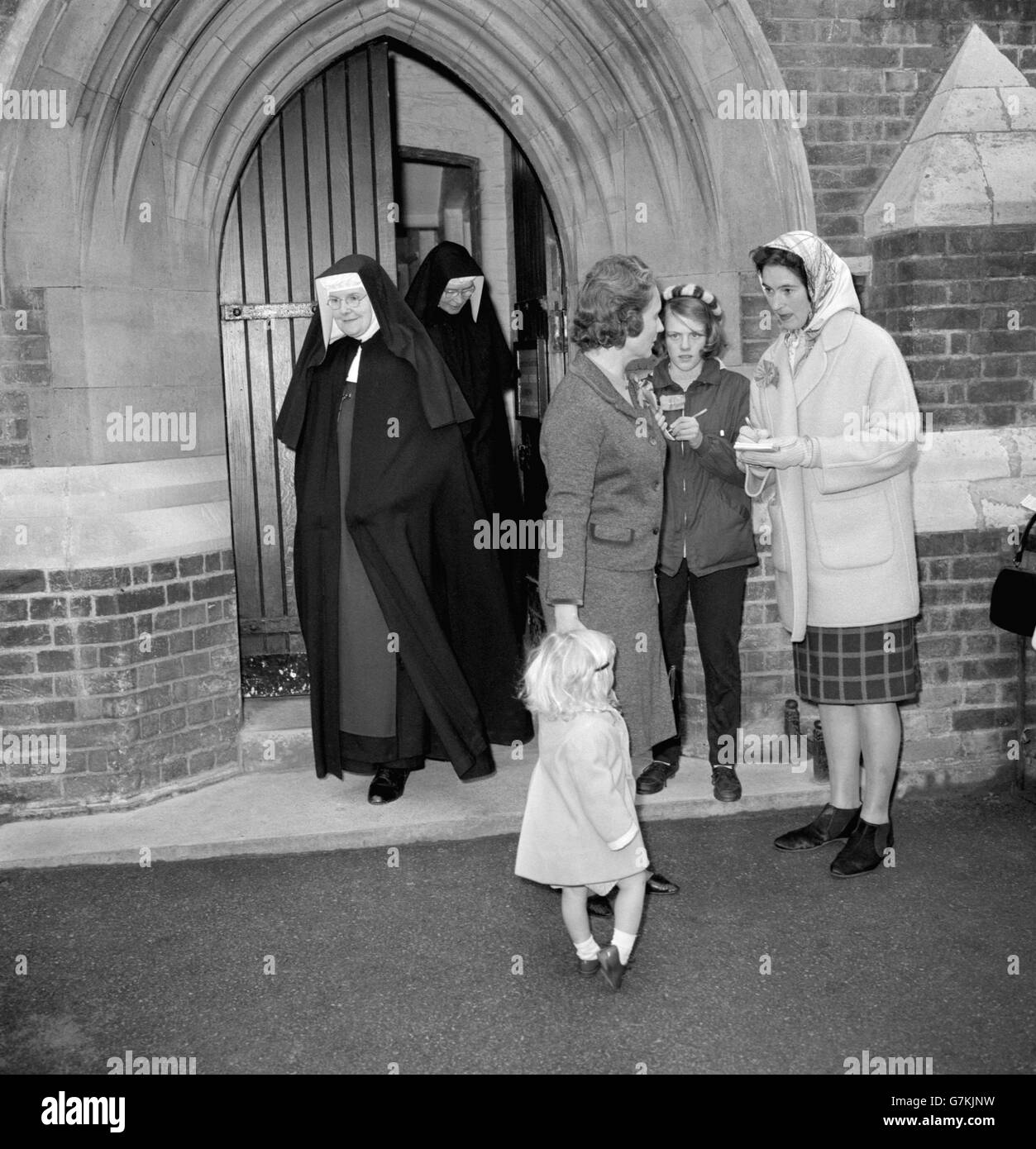 Mrs Quintin Hogg, wife of the Minister for Science, with her daughter Katherine after casting her vote at the Church of England School polling station in Ponsonby Road, Roehampton, London. In the background can be seen nuns from the nearby St Mary's Convent, who had just cast their votes. Stock Photo