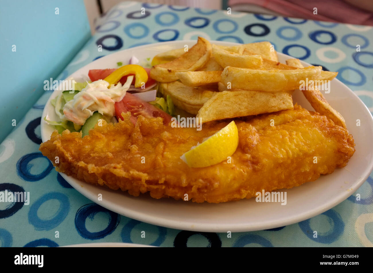 cod fish and chips with salad  displaid on a china plate in whitstable town coast in kent uk june 2016 Stock Photo