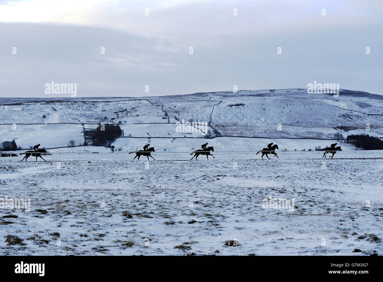 Racehorses exercise on the snowy gallops at Middleham, as Britons were warned to brace themselves for fresh disruption today as snow freezes over, bringing potentially perilous road conditions. Stock Photo