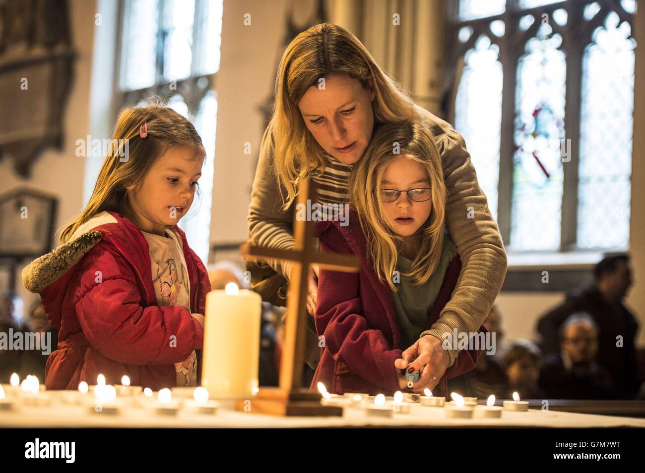 Kate Thomas helps her daughters Chloe, 5 (left) and Isabel, 7, light a candle in memory of those that died after a special service of prayer at All Saints Church in Weston, Bath, after an out-of-control tipper truck killed four people on nearby Lansdown Lane yesterday. Stock Photo