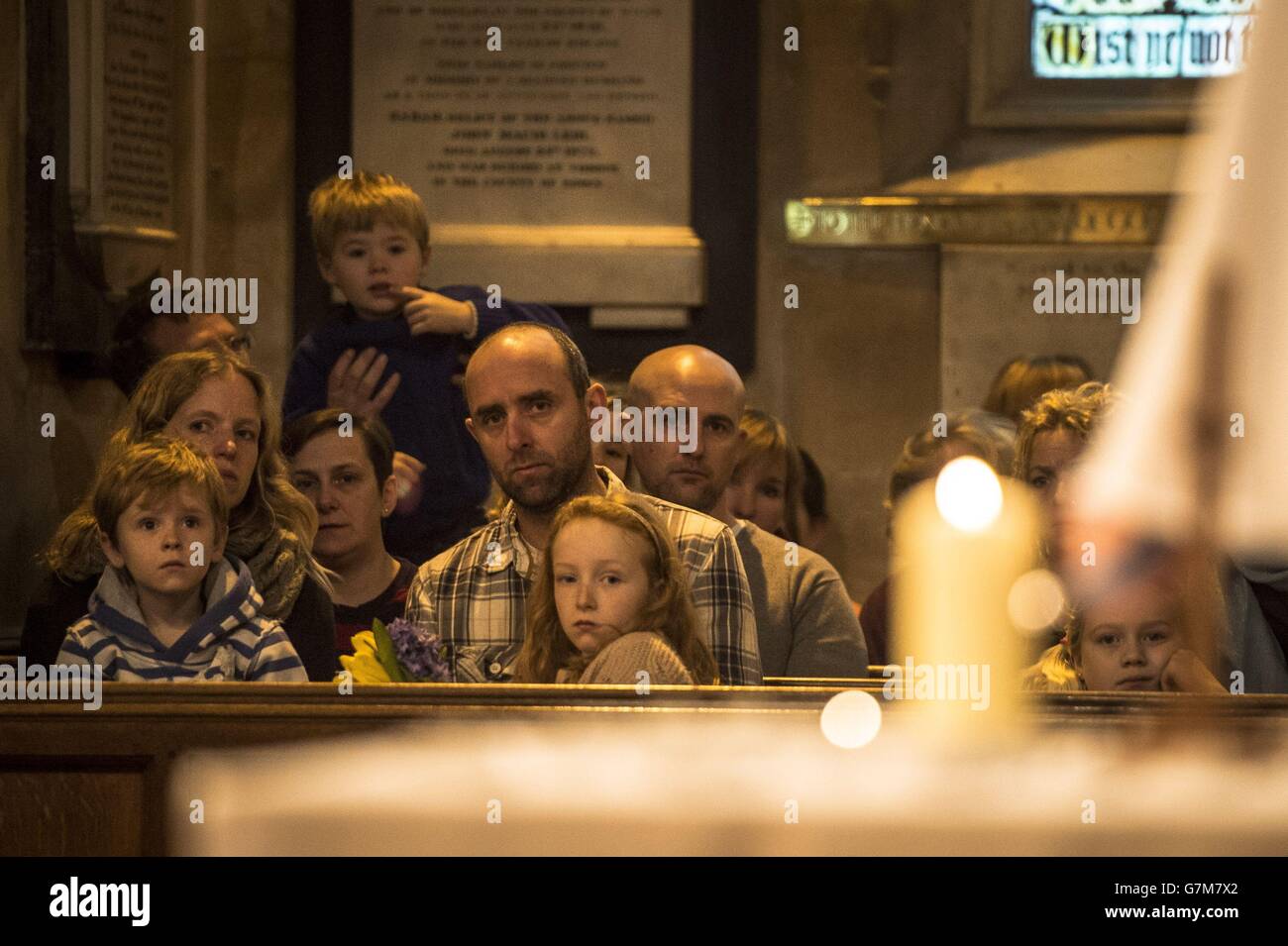 People watch candles being lit in memory of those who died as they attend a special service of prayer at All Saints Church in Weston, Bath, after an out-of-control tipper truck killed four people on nearby Lansdown Lane yesterday. Stock Photo
