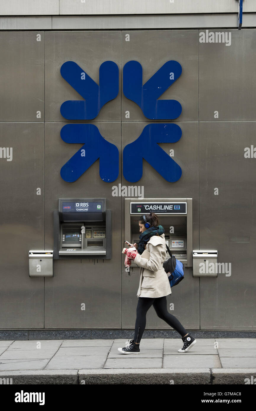 A woman walks past a set of Royal Bank of Scotland (RBS) cash machines