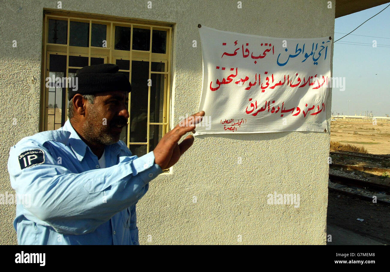 An Iraqi Police officer outside a check point, where a Banner has been put up calling for support in voting for the United Iraqi Alliance in next weekend's national elections. Stock Photo
