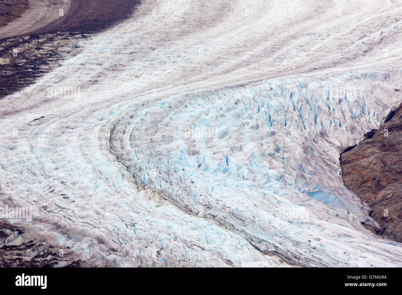 Curving, receding view of Salmon Glacier ice and its exposed rocky ground. Stock Photo
