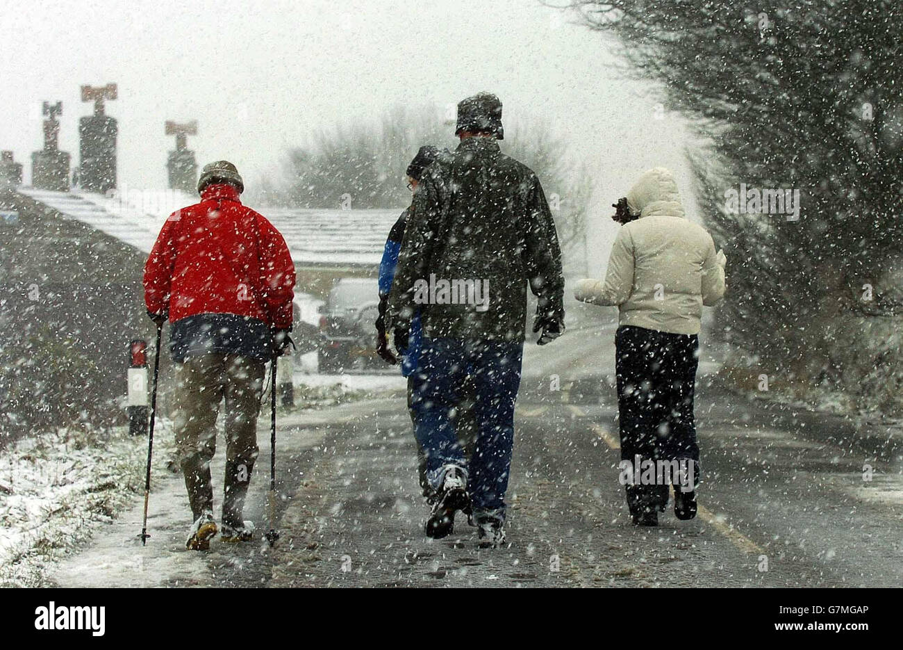 Christmas Day snowfalls give a seasonal look to the hills as walkers are undeterred by the weather. Stock Photo