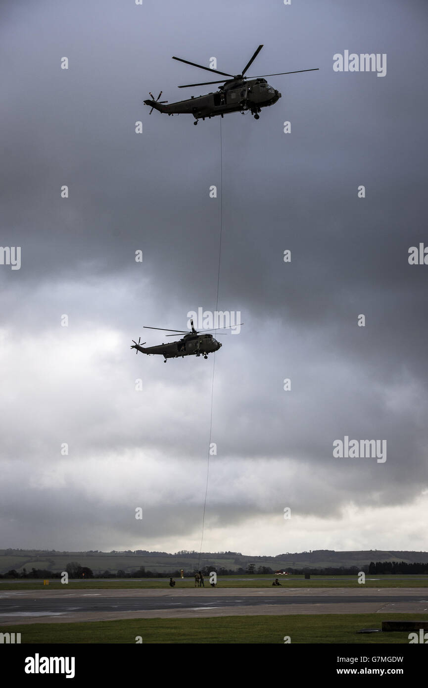 Royal Navy Merlin helicopters perform a tactical manoeuvre for sailors, officers and their family and friends after a 'wings' ceremony attended by the Duke of York at Royal Naval Air Station Yeovilton, Somerset. Stock Photo